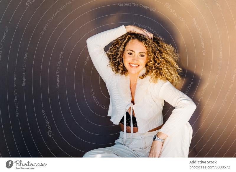 Confident woman in white clothes sitting on floor model studio shot makeup gorgeous charismatic confident self assured appearance individuality young lady