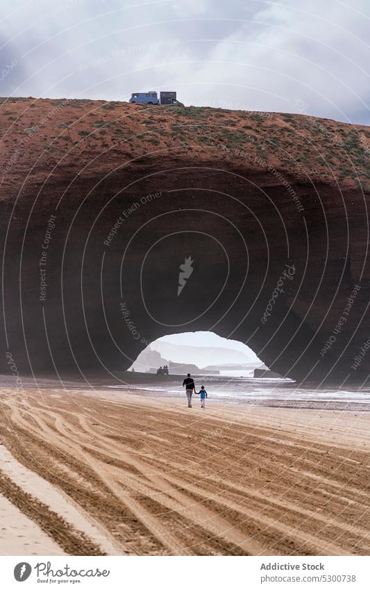 Unrecognizable travelers walking along sandy desert people bridge nature landscape sky tourism stone together mauritania sahara cloudy trip tourist terrain