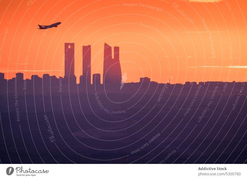 Plane flying over city buildings sunset plane silhouette sky cityscape architecture sundown madrid cuatro torres four towers twilight spain airplane aviation