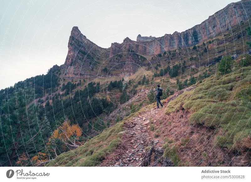 Traveler taking photo of rocky mountains while standing on slope man traveler take photo admire nature tourism environment ordesa pyrenees of huesca spain