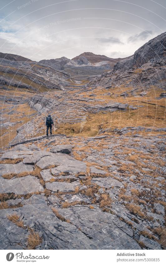 Traveler walking on rocky valley near mountains man traveler terrain nature rough trekking ordesa pyrenees of huesca spain europe location tourist backpack