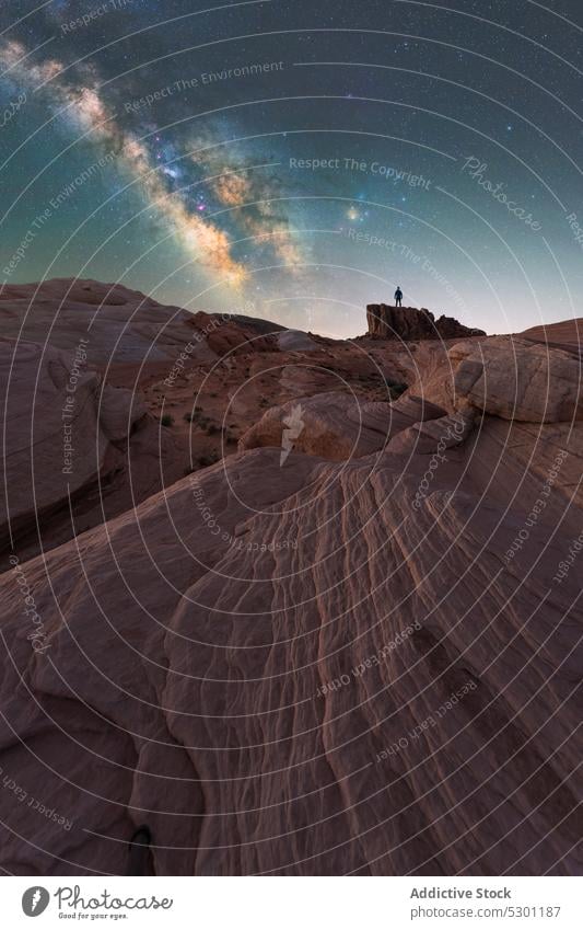 Unrecognizable traveler admiring starry sky on rocky terrain night admire milky way mountain scenic adventure nature valley of fire state park nevada usa galaxy