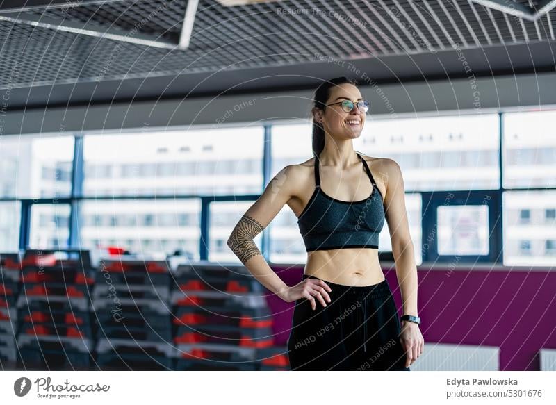 Portrait of a athletic young woman in a gym wellness wellbeing bodybuilder sporty lifting biceps muscles barbell bodybuilding people muscular adult person