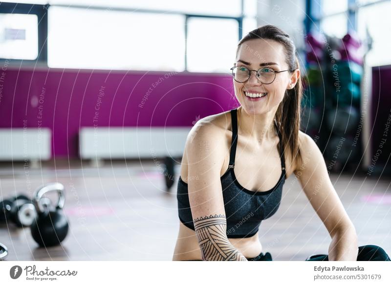 Portrait of a athletic young woman in a gym wellness wellbeing bodybuilder sporty lifting biceps muscles barbell bodybuilding people muscular adult person