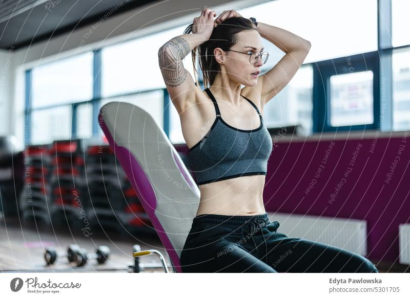 Portrait of a athletic young woman exercising in a gym wellness wellbeing bodybuilder sporty lifting biceps muscles barbell bodybuilding people muscular adult