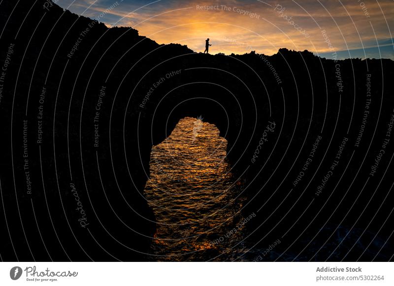 Picturesque view of rocky bridge in sunset time sea water nature sundown sky evening silhouette cliff pont den gil ciutadella menorca balearic islands spain