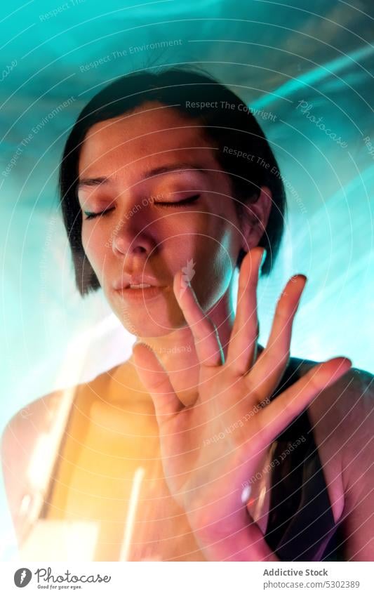 Calm woman with short hair and eyes closed stop gesture confident sign portrait concept serious model reject female young appearance brunette gaze refuse