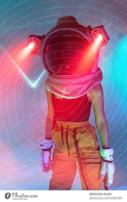 Woman in cosmonaut helmet with neon light woman astronaut model serious confident futuristic portrait appearance style illuminate female glow personality gaze