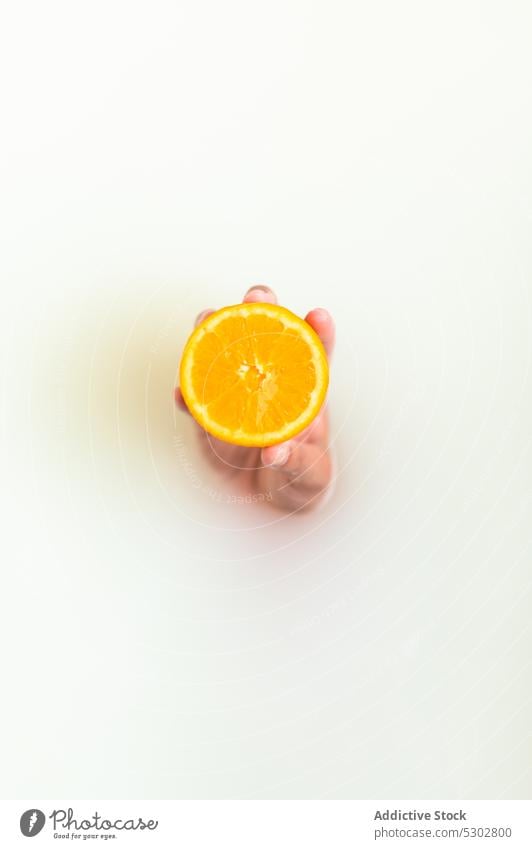 Female hand showing orange slice in milk bath woman citrus fresh fruit hydrate rejuvenate vitamin spa healthy tub at home clean procedure care food liquid