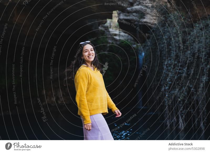 Happy woman enjoying vacation near trees and rocks tourist waterfall river cheerful happy nature smile countryside summer travel casual traveler female young