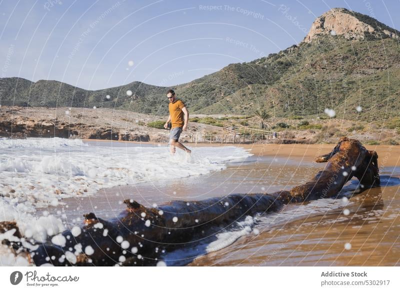 Man walking on beach during summer vacation man sea wave shore nature tourist mountain water coast ocean male blue sky seashore traveler tourism scenic seaside