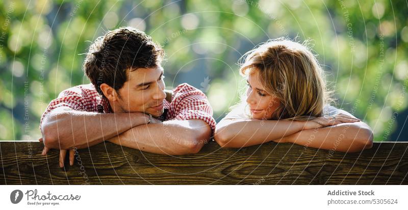 Couple in traditional clothes looking at each other couple sitting bench garden austrian clothing sunny daytime man woman park happy lifestyle smiling leisure