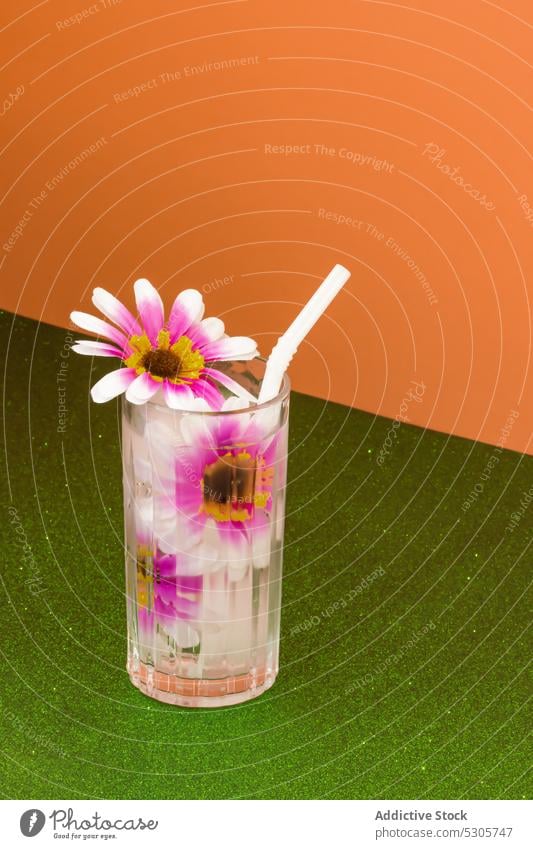 Glass of fresh cocktail with flowers and straw beverage drink refreshment glass cold alcohol bloom delicious colorful plant bright pink transparent tasty