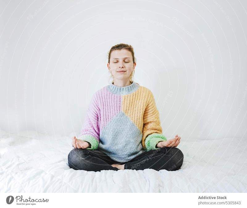 Calm woman meditating on bed meditate lotus pose yoga zen home practice mindfulness calm female eyes closed relax peaceful padmasana meditation spirit serene