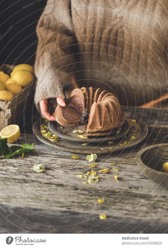 Anonymous person taking slice of delicious chocolate cake in table breakfast lemon fruit citrus box food dessert lemon cake vegan cake plant-based ripe hand eat