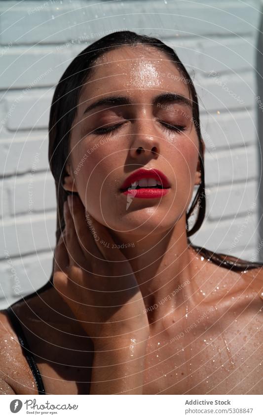 Alluring woman enjoying outdoor shower on sunny day wet sexy sensual touch neck seductive allure wash naked hygiene relax female young wet hair model water