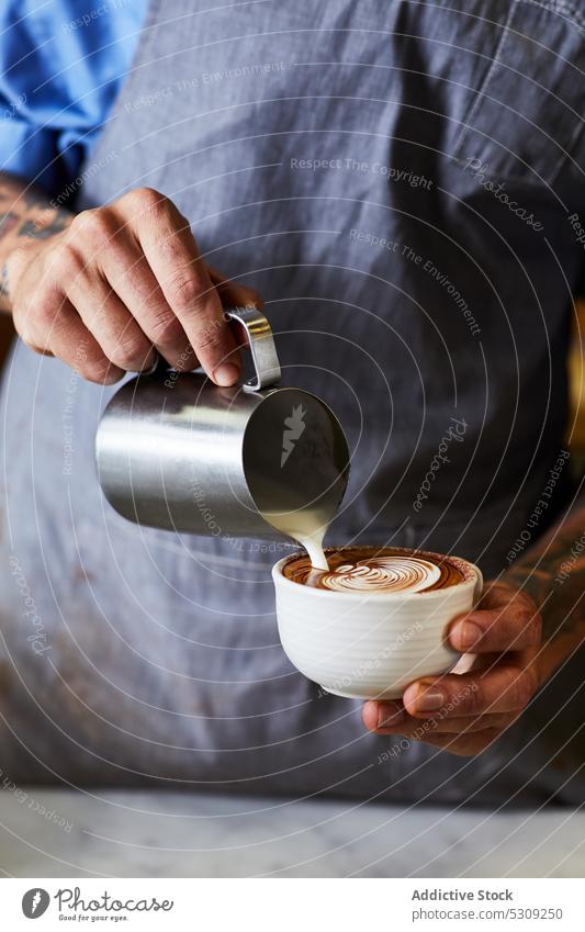 Crop barista pouring milk into cappuccino in cafe man coffee prepare foam froth latte male coffee shop latte art cup caffeine drink beverage work job jug fresh