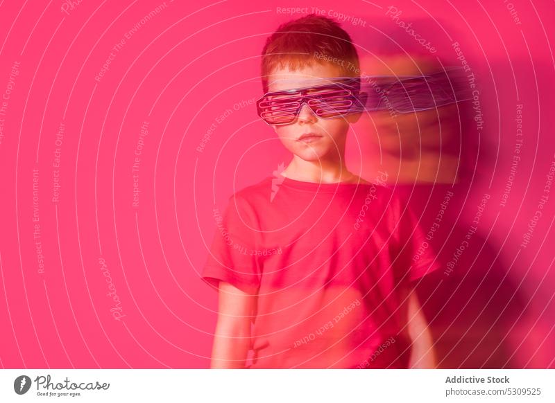 Serious boy in futuristic glasses looking at camera style kid colorful confident bright modern serious child vivid shirt vibrant trendy outfit neon personality