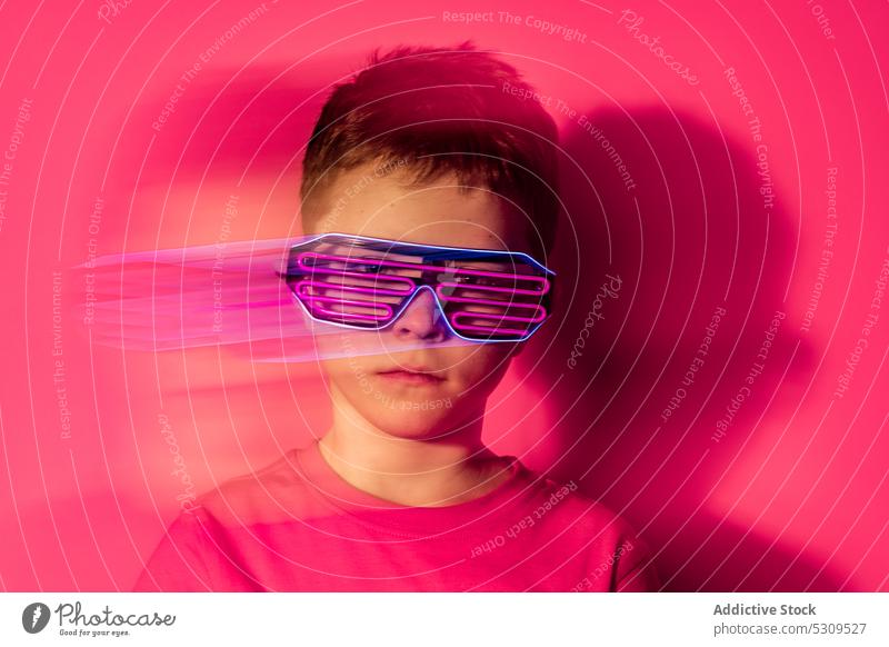 Serious boy in futuristic glasses looking at camera style kid colorful confident bright modern serious child vivid shirt vibrant trendy outfit neon personality