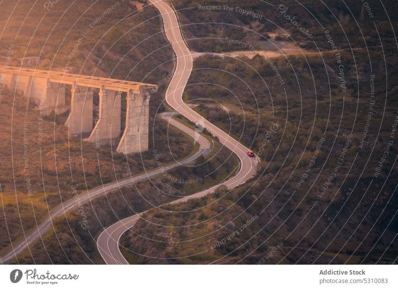 Drone view of car on highway road nature mountain tree curve drive ride madrid spain atazar terrain route transport lush environment landscape forest vegetate