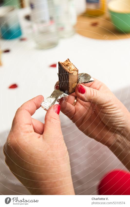 Mainfux | First a piece of chocolate! hands red fingernails Women's Hands Chocolate unwrap Fingers To hold on Skin Close-up Stanio paper Nougat chocolate nougat