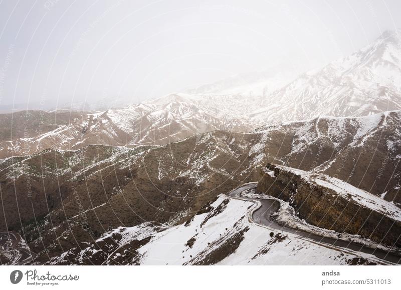 Snowy winding road in the mountains Hill Street Curve Brown Pass Fog Mystic Morocco Atlas