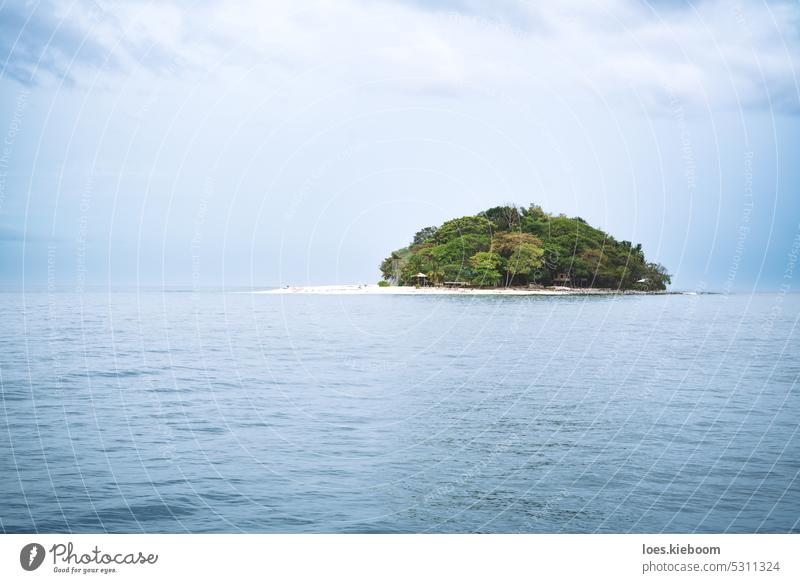 Small remote white beach island with lush green trees in light blue ocean, Palawan, Philippines philippines destination palawan dramatic seascape shore tropical