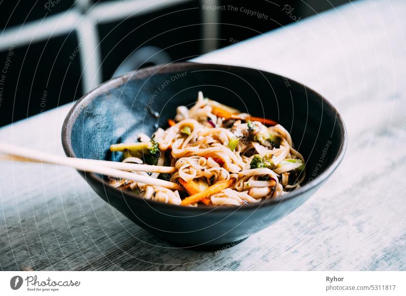 View osf asian noodles udon with pork close-up in a bowl on the table black chili chinese chopsticks closeup cooked cooking cuisine delicious dinner dish food