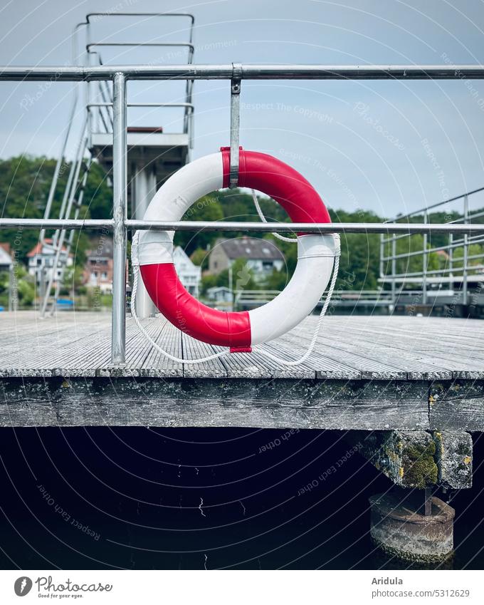 Lifebelt on the railing of a jetty at the bathing lake boats Footbridge Swimming lake Jumping tower Deserted Safety Exterior shot Letters (alphabet) peril