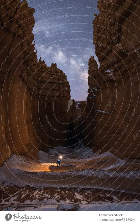 Anonymous tourist walking in desert valley at night traveler flashlight canyon mountain nature rock admire wanderlust hike rocky spectacular journey explore