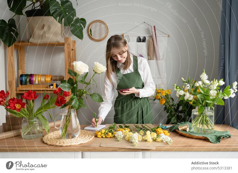 Happy female florist browsing smartphone woman watching order flower shop store happy work write conversation receive sell workshop floristry smile occupation