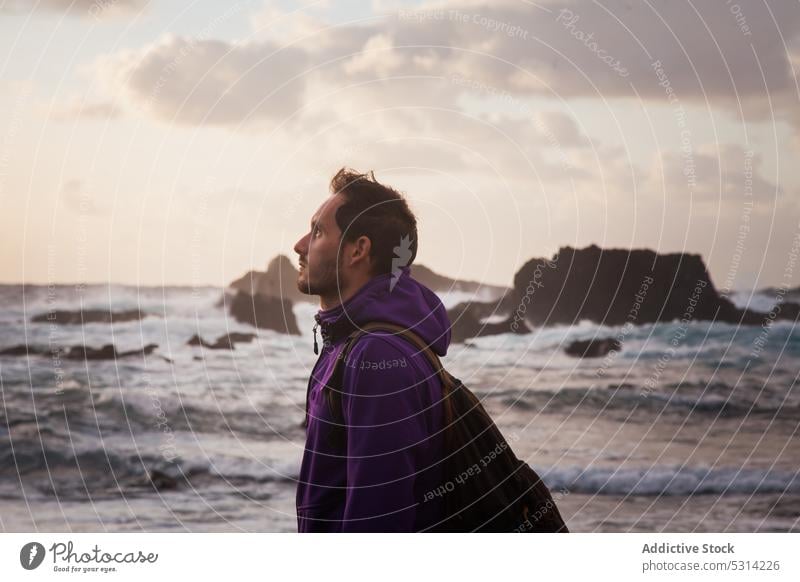 Man standing in front of sea man shore sunset beach cloudy sky coast traveler ocean evening sundown vacation wave water male relax dusk rest twilight admire