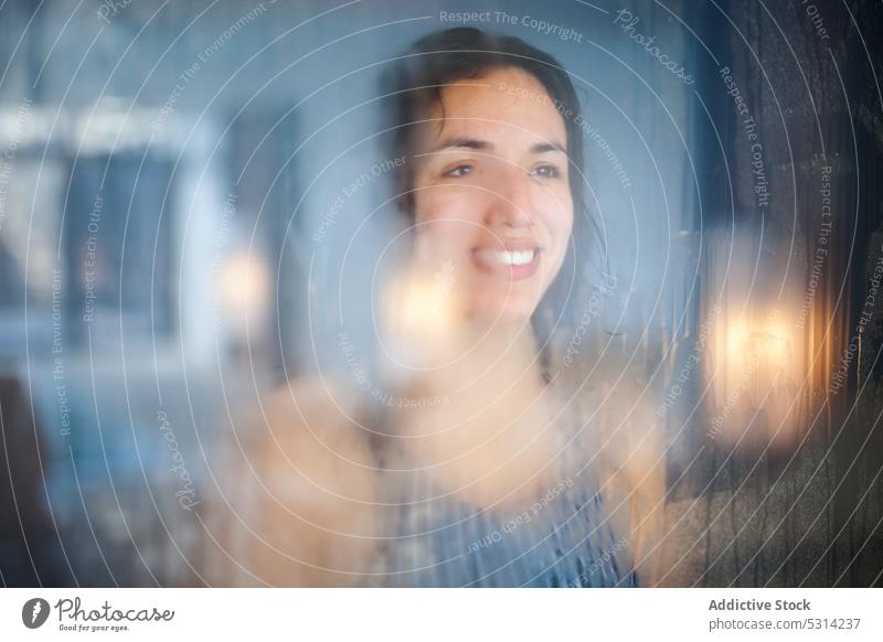 Smiling woman looking at window pool cheerful reflection transparent happy glass resort water through glass female enjoy young smile relax looking away