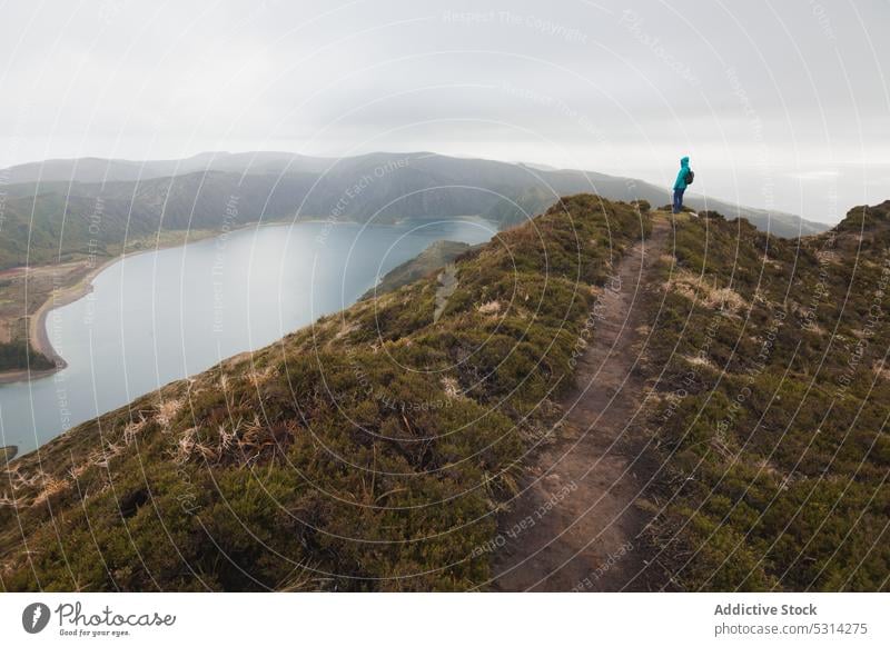 Female traveler admiring lake from mountain woman trip distant ridge admire gloomy rain azores island portugal europe scenery hill picturesque majestic wild