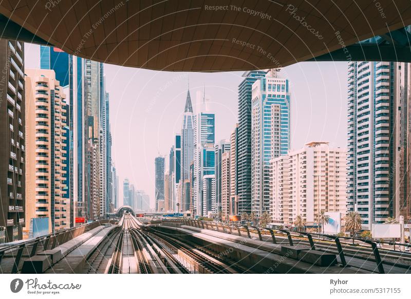 Modern Dubai Metro. Metro railway among glass skyscrapers in Dubai. Traffic on street in Dubai. Urban city background. Modern with skyscrapers architecture of Dubai, UAE