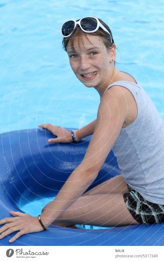 Teenagers in swimming ring in blue pool. Youth (Young adults) teenager Water fun Summer be afloat Resort Blue free time Girl vacation Wet Sports Lifestyle