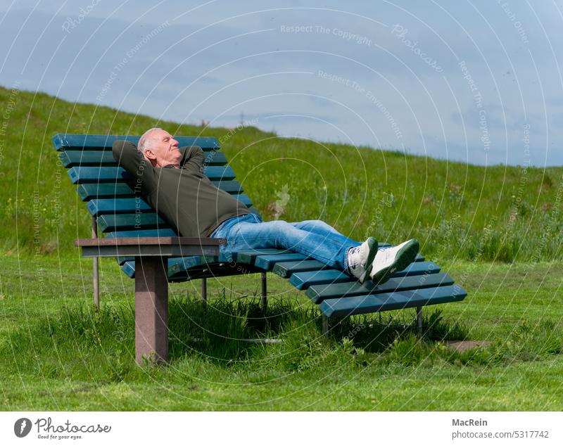 Relaxation on ener park bench 60-70 years old Pensioners relax free time Man rest vacation destination Helgoland Island Helgoland