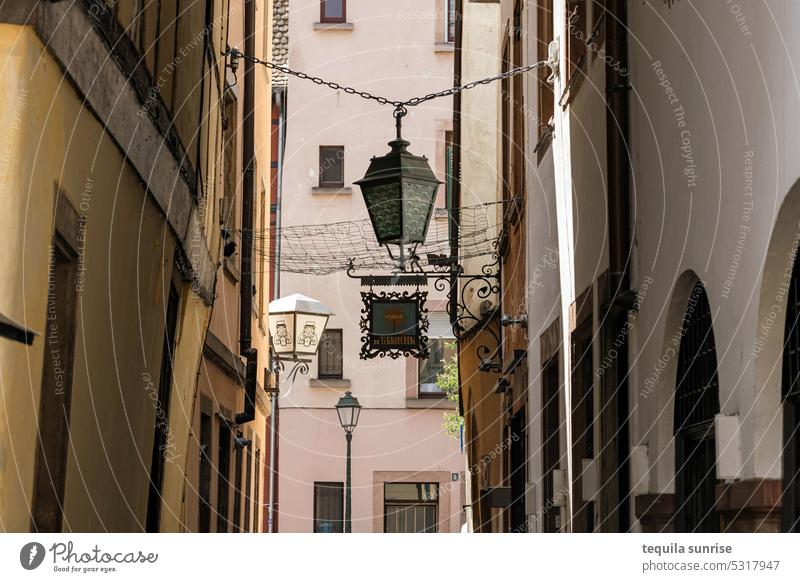 Lanterns in a side street Strasbourg Alsace Street lighting streetlamp Hanging lantern Sidestreet houses Pedestrian precinct France Restaurant