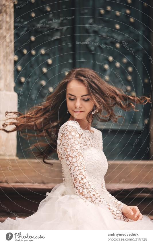 portrait of a beautiful young bride in a white wedding dress with long hair in the old European city. Woman near old building. wedding day girl town woman