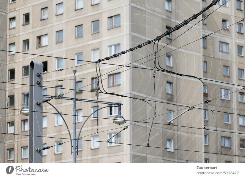 Streetcar overhead line forms pattern in front of the facade of a prefabricated building Overhead line stream Electricity Tram lines Pattern PUBLIC TRANSPORT