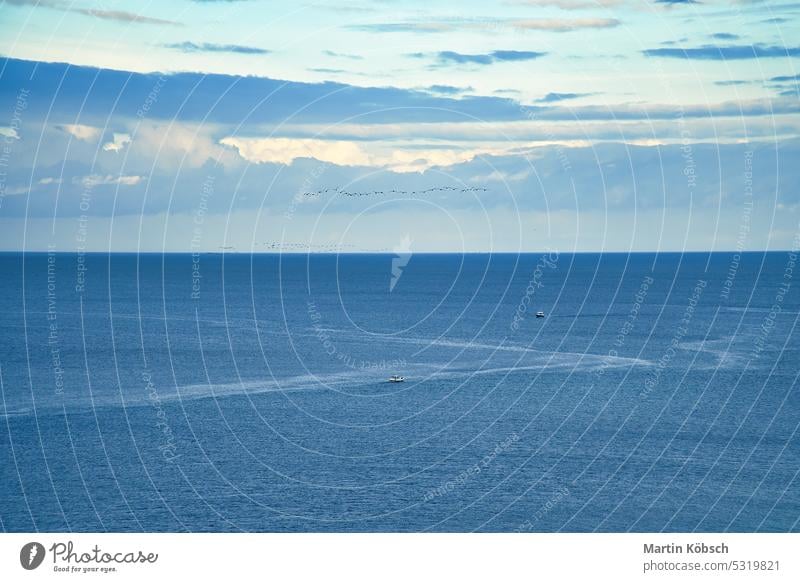 open sea with view from a hill. two boats in the water. Sunny sky beach sand vacation waves travel landscape sunset ocean darss clouds light mood coast evening