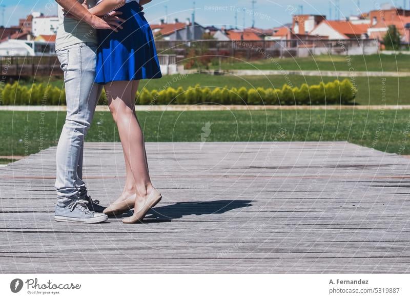 Detail of a young couple kissing. She stands on her toes hugging standing on the toes standing on toes Toes detail Looking in love Couple photo Relationship