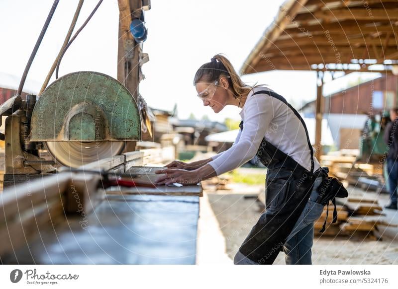 Carpenter cutting plank by circular saw in a sawmill real people woodshop carpenter entrepreneur expertise craftsperson creativity manufacturing crafts people