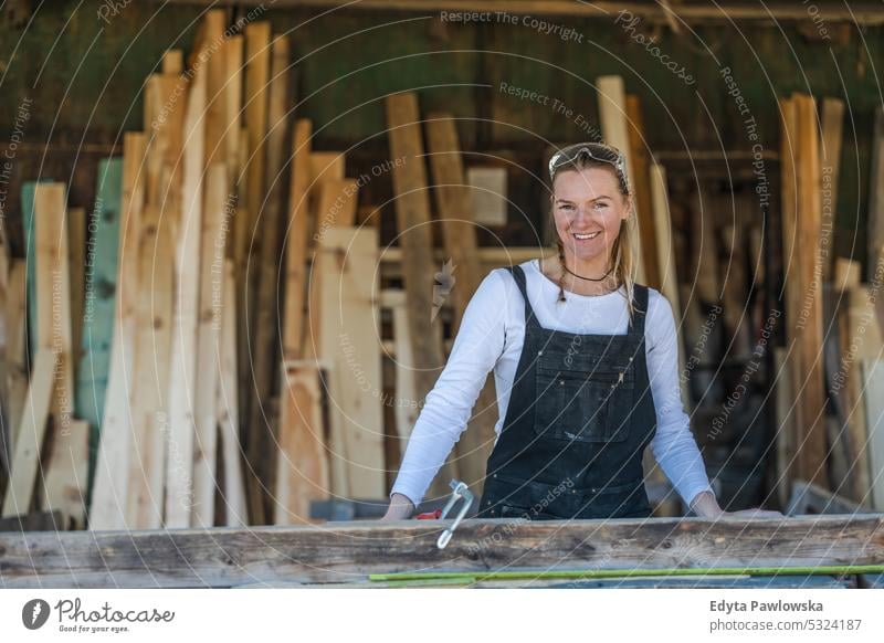 Woman working with wooden planks in a sawmill real people woodshop carpenter entrepreneur expertise craftsperson creativity manufacturing crafts people hobby