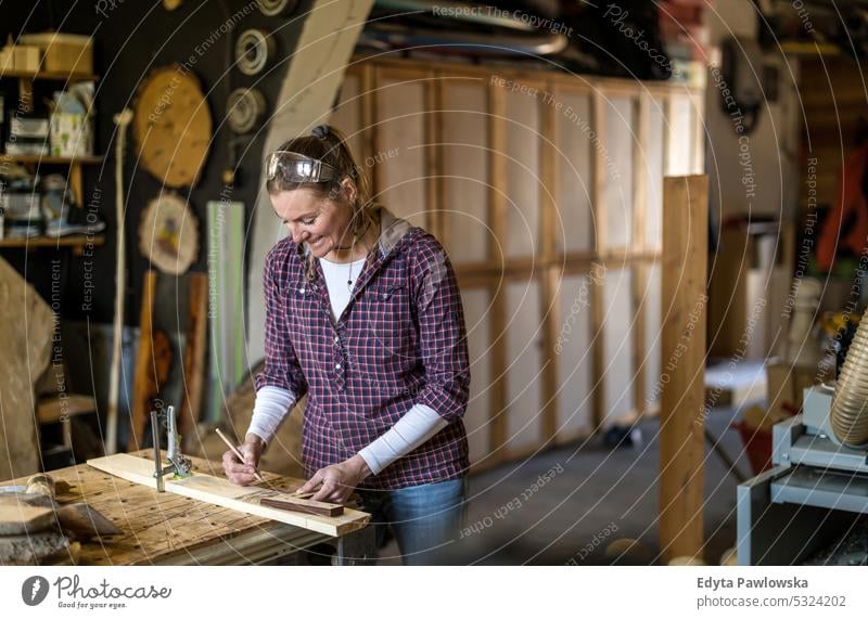 Craftswoman working with wood in carpentry workshop real people woodshop carpenter entrepreneur expertise craftsperson creativity manufacturing crafts people