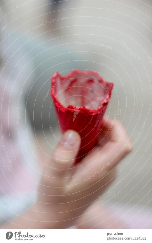 a child holds a red, nibbled ice cream cone with leftover ice cream in his hand. Ice-cream cone eat ice cream especially Red Infancy enjoyment Joy Delicious