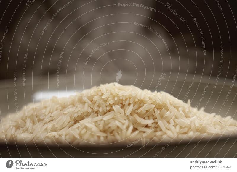 Hot white Thai jasmine long grain rice with steam in a bowl. Organic vegetarian healthy food. Heathy nutritious dish. Close up slow motion. Macro shot meal