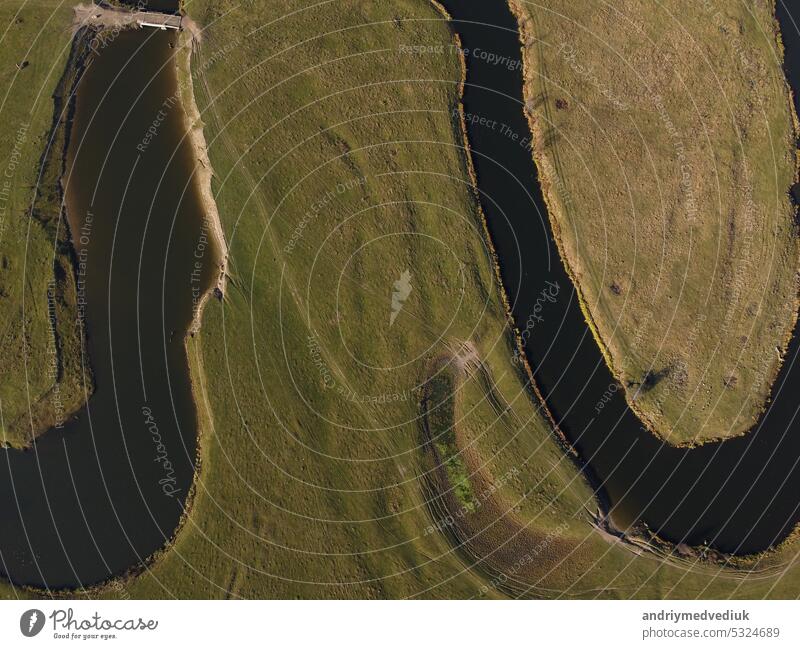 aerial view of a beautiful winding river flows among the fields, which flows picturesquely, creating incredible landscapes. between flooded fields and swamps.