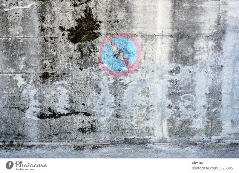 a painted and slowly dissolving traffic sign - restricted no stopping - on a gray old wall Clearway limited holding ban no parking Road sign Wall (building)