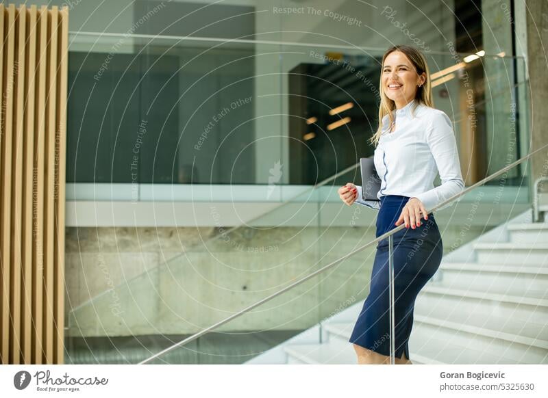 Yyoung business woman walking on stairs in the office hallway adult beautiful building businesspeople businesswoman caucasian ethnicity coworker daytime